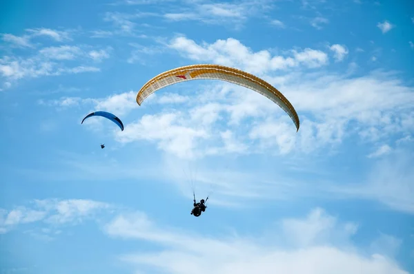 İki paraşütler bulutlar arka planı mavi gökyüzünde uçan. — Stok fotoğraf