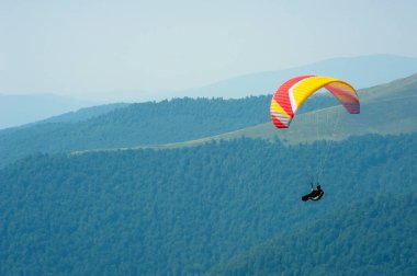 Yamaçparaşütü dağ Vadisi bir güneşli yaz gününde uçar.. 