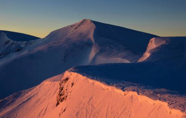 Kışın harika gündoğumu Karpatlar içinde. Gündoğumu kırmızı ışınlarının kış dağların zirveleri karla kaplı.