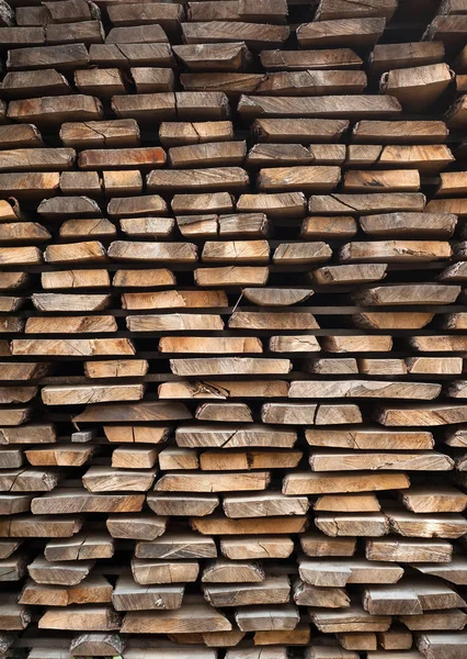 Folded wooden brown and gray planks in a sawmill. Piled alder bo — Stock Photo, Image