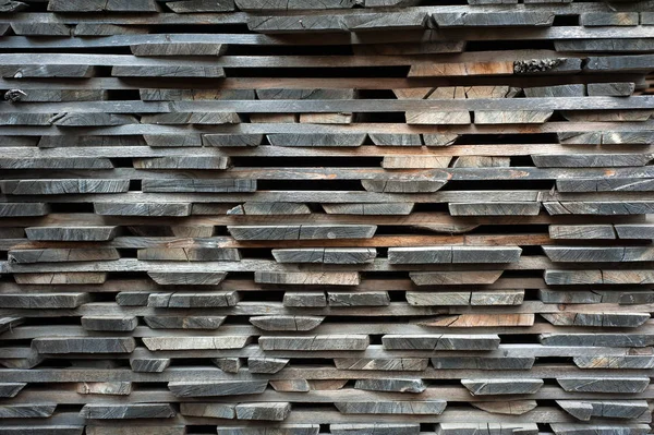 Gefaltete braune und graue Holzbohlen in einem Sägewerk. aufgeschichtete Erle — Stockfoto