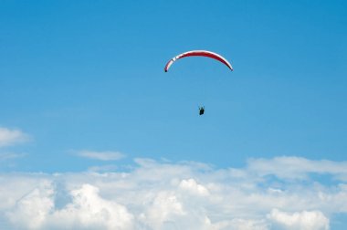 Yalnız Yamaçparaşütü bulutlar arka planı mavi gökyüzünde uçan. 