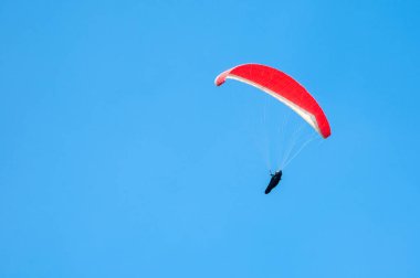 Yalnız Yamaçparaşütü mavi gökyüzünde uçan. Gökyüzünde yamaç paraşütü 