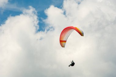Yalnız Yamaçparaşütü bulutlar arka planı mavi gökyüzünde uçan.