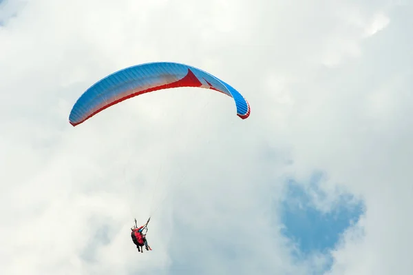 Seul parapente volant dans le ciel bleu sur fond de nuages . — Photo