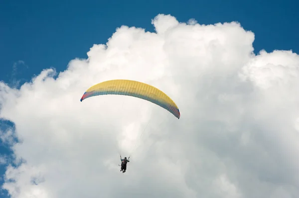 Alone paraglider flying in the blue sky against the background of clouds. — Stock Photo, Image