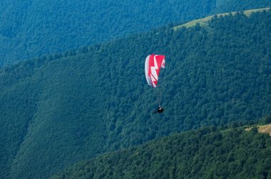 Yamaçparaşütü bir güneşli yaz gününde bir dağ Vadisi uçar. P