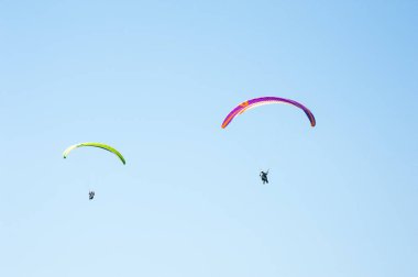 İki paraşütler mavi gökyüzü arka plan üzerinde uçan. 