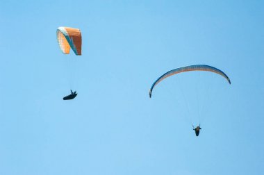 İki paraşütler mavi gökyüzü arka plan üzerinde uçan. 