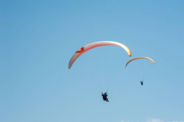 İki paraşütler mavi gökyüzü arka plan üzerinde uçan. 