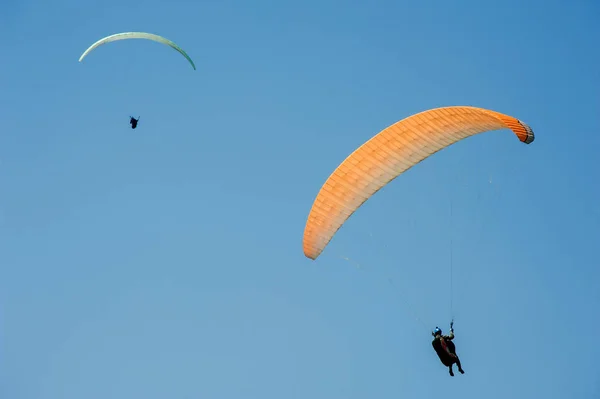 Två paragliders flyger på bakgrund av blå himmel. — Stockfoto