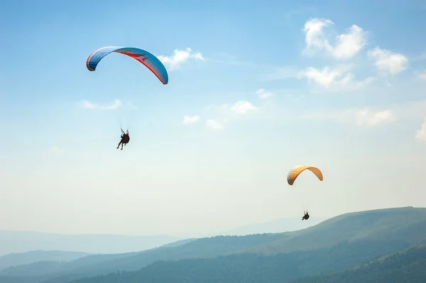 两个滑翔伞飞越山谷在阳光明媚的夏日. — 图库照片