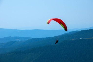 Yamaçparaşütü dağ Vadisi bir güneşli yaz gününde uçar.. 