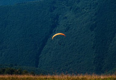 Yamaçparaşütü dağ Vadisi bir güneşli yaz gününde uçar.. 