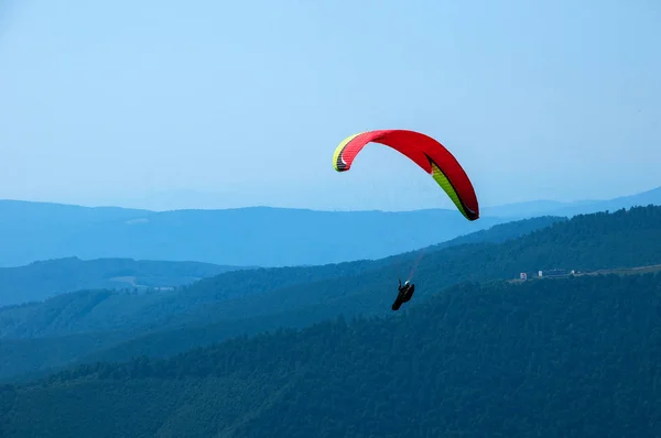 Paraglider flies over a mountain valley on a sunny summer day. — Stock Photo, Image