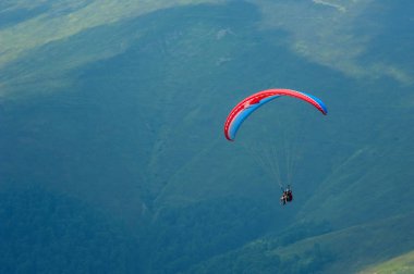 Yamaçparaşütü bir güneşli yaz gününde bir dağ Vadisi uçar. Karpatlar yaz aylarında yapılan yamaç paraşütü. 