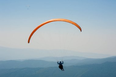 Yamaçparaşütü dağ Vadisi bir güneşli yaz gününde uçar.. 