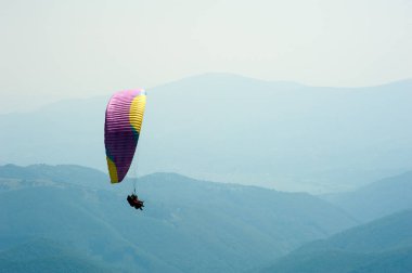 Yamaçparaşütü dağ Vadisi bir güneşli yaz gününde uçar.. 