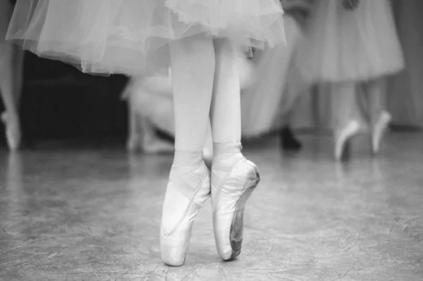 Primo piano dei piedi della ballerina sulle scarpe da punta nella sala da ballo. Fotografia vintage . — Foto Stock