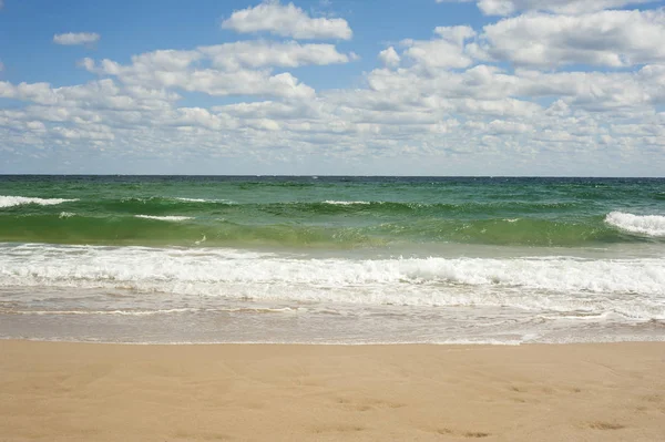Onda azul do mar na praia. Belas ondas do mar em um fundo de céu azul com nuvens em um dia ensolarado de verão . — Fotografia de Stock