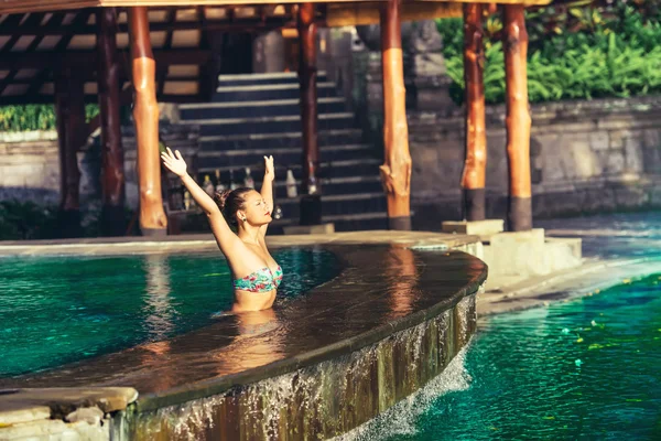 Retrato de una hermosa mujer en la piscina, nadando y tomando el sol en un amanecer luz dorada —  Fotos de Stock