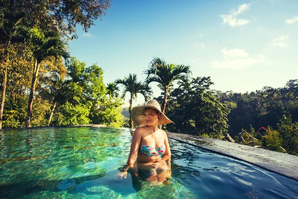 Güzel güzel esmer kız güneşli bir sonsuzluk havuzu zevk — Stok fotoğraf