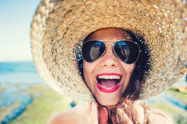 Hipster fajna dziewczyna, młoda kobieta gra z kapelusz na plaży w słoneczny letni dzień. — Zdjęcie stockowe