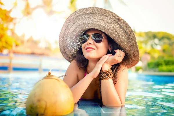 Jong meisje drinken kokosnoot cocktail, aantrekkelijk en sexy jonge vrouw met verfrissing drinken in poep — Stockfoto