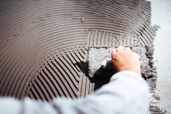 Primo piano industriale di mano lavoratore l'aggiunta di adesivo per l'installazione di piastrelle di ceramica — Foto Stock