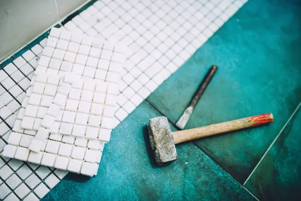 Detalhes industriais da construção de casa - Martelo e mosaico, telhas de cerâmica de pedra de mármore branco — Fotografia de Stock