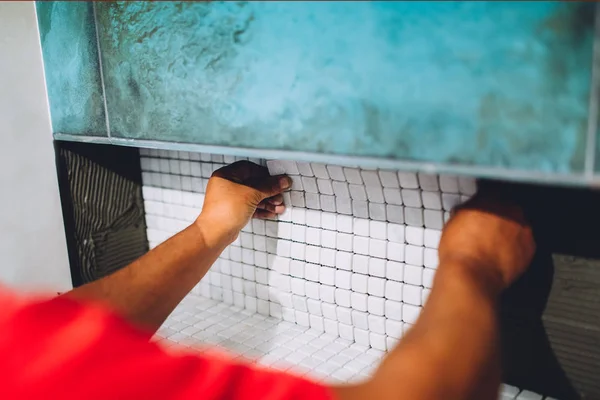 Construction worker placing ceramic mosaic boards on flexible adhesive. Worker hands working with ceramic tiles — Stock Photo, Image