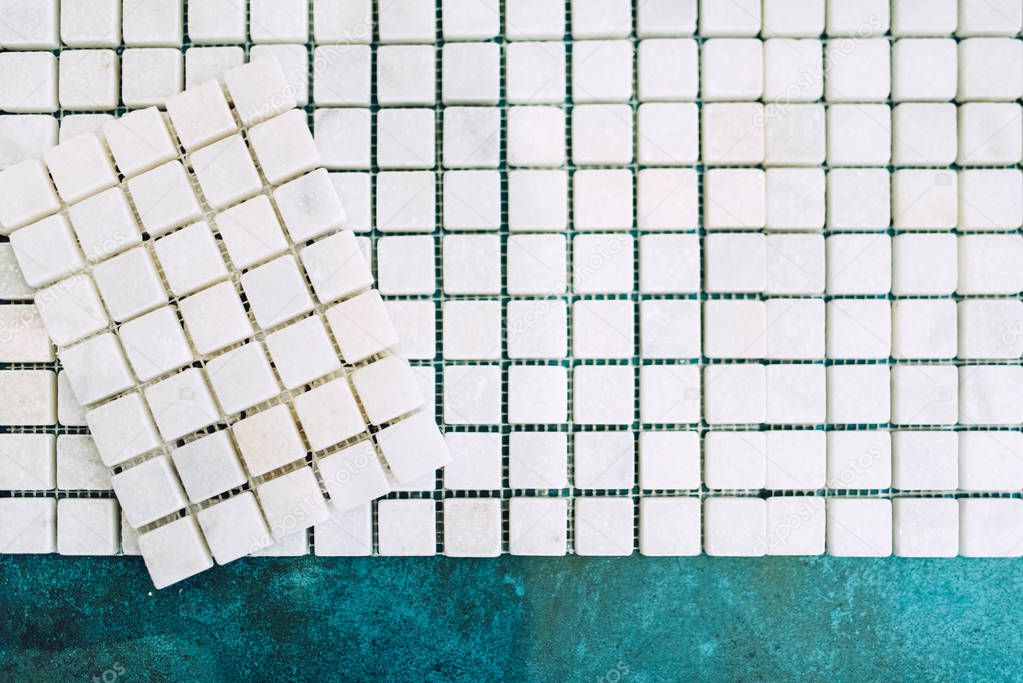 Close up details of home renovation - white marble decorative mosaic pattern ready to be applied on bathroom walls