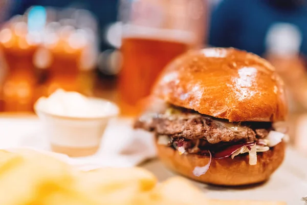 Leckere gegrillte Rind-und Schweineburger mit Mayo und Kohl serviert im Restaurant, Pub oder Bistro auf Teller mit Pommes. modernes Abendessen mit Burger und Pommes — Stockfoto