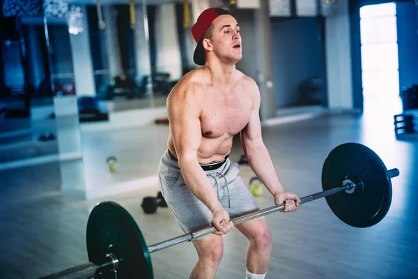 Primer plano retrato de un macho musculoso, entrenamiento con barra de pesas en el centro de entrenamiento, en el gimnasio —  Fotos de Stock