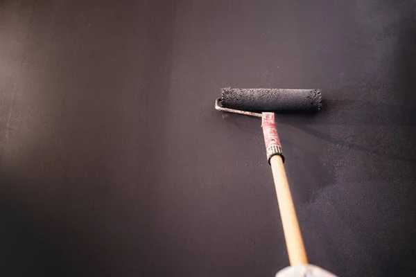 Trabajador decoración de paredes con pintura gris. Construcción yeso trabajador pintura y renovación con herramientas profesionales — Foto de Stock