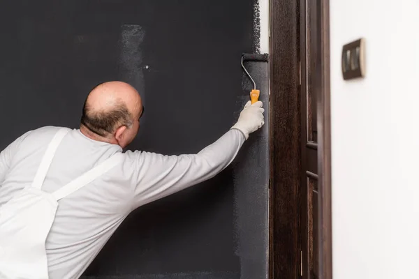 Trabalhador da construção civil rebocando uma parede, pintura com decoração de pincel em paredes interiores — Fotografia de Stock