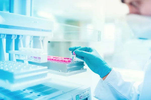 Primer plano del científico químico que sostiene la muestra y examina el tubo de ensayo en un laboratorio especial —  Fotos de Stock