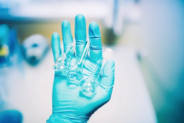 Close up of scientist rubber glove holding small glass containers. Chemical Engineer working with analyzing tubes — Stock Photo, Image