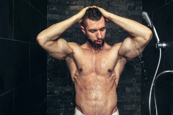 Hombre guapo de fitness tomando una ducha en la mañana. Atleta de aspecto natural duchándose —  Fotos de Stock