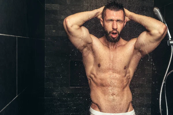 Un bell'uomo nudo che si fa la doccia. Uomo muscolare doccia dopo l'allenamento — Foto Stock