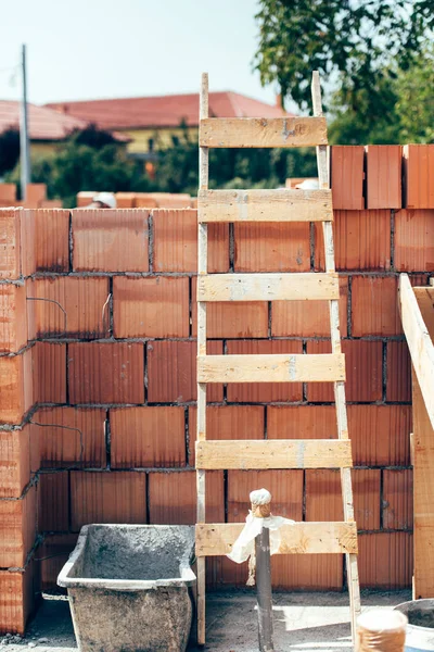 Holzleiter auf Baustelle. Details von Mauerwerk und Holzwerkzeugen — Stockfoto
