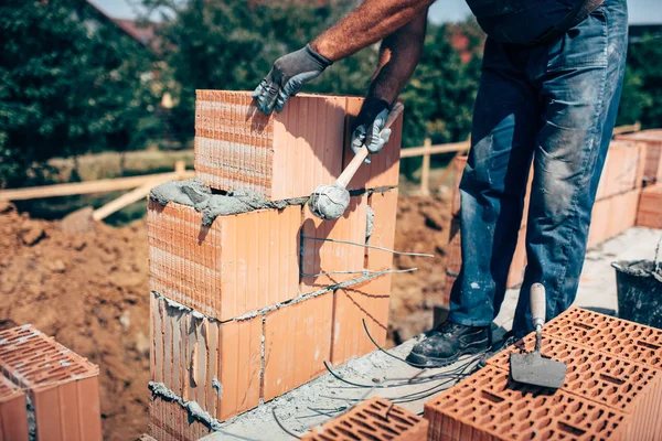 Obrero de la construcción industrial, obrero albañil profesional colocando ladrillos en el cemento mientras construye paredes exteriores, detalles de la industria —  Fotos de Stock