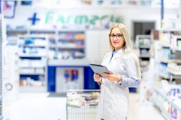 Pharmazieprofi mit Tablette im pharmazeutischen Bereich. Medizinische Details mit blonder Apothekerin — Stockfoto