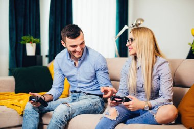 Genç evli çift ile modern teknoloji konsol online, video oyunları oynamak ve hafta sonu zevk eğleniyor 