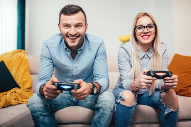 Genç çift oyun video oyunları genel oyun konsolu üzerinde evlendi. Eğleniyor çift ile modern yaşam tarzı ayrıntılarını