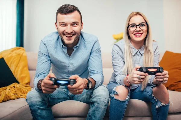 Junges Ehepaar beim Spielen von Videospielen auf allgemeinen Spielkonsolen. Details des modernen Lebensstils mit spaßigen Paaren — Stockfoto