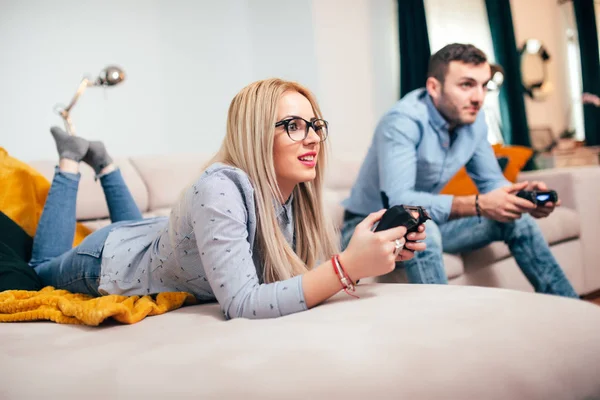 Ευτυχισμένο ζευγάρι ερωτευμένων απολαμβάνοντας δωρεάν χρόνο παίζοντας βιντεοπαιχνίδια και τη διασκέδαση στο μοντέρνο διαμέρισμα. — Φωτογραφία Αρχείου