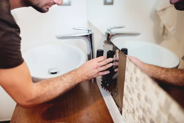 Εργαζόμενος intalling ψηφιδωτά πλακάκια και χρησιμοποιώντας βιομηχανικές σπάτουλα σε μοντέρνο μπάνιο — Φωτογραφία Αρχείου