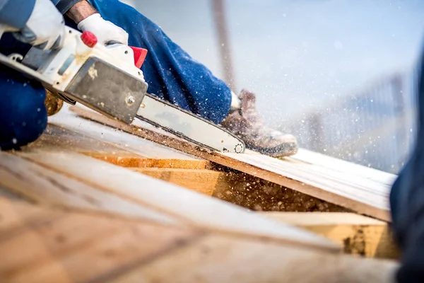 Industriarbetare styckning trä plankor använder elektriska såg. Detaljer för byggarbetsplatsen — Stockfoto