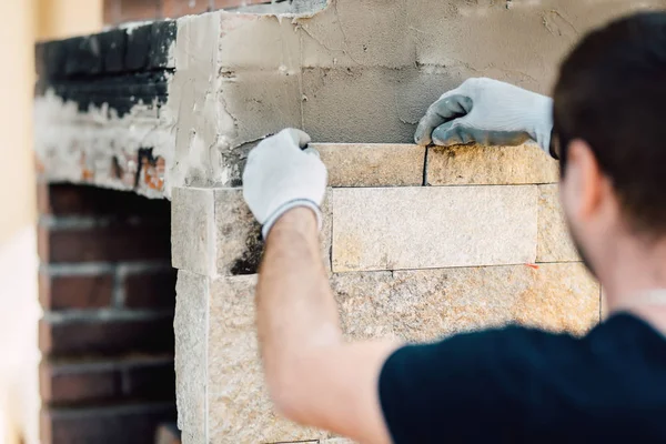 Obrero de la construcción renovando paredes exteriores e instalando piedra con mortero — Foto de Stock